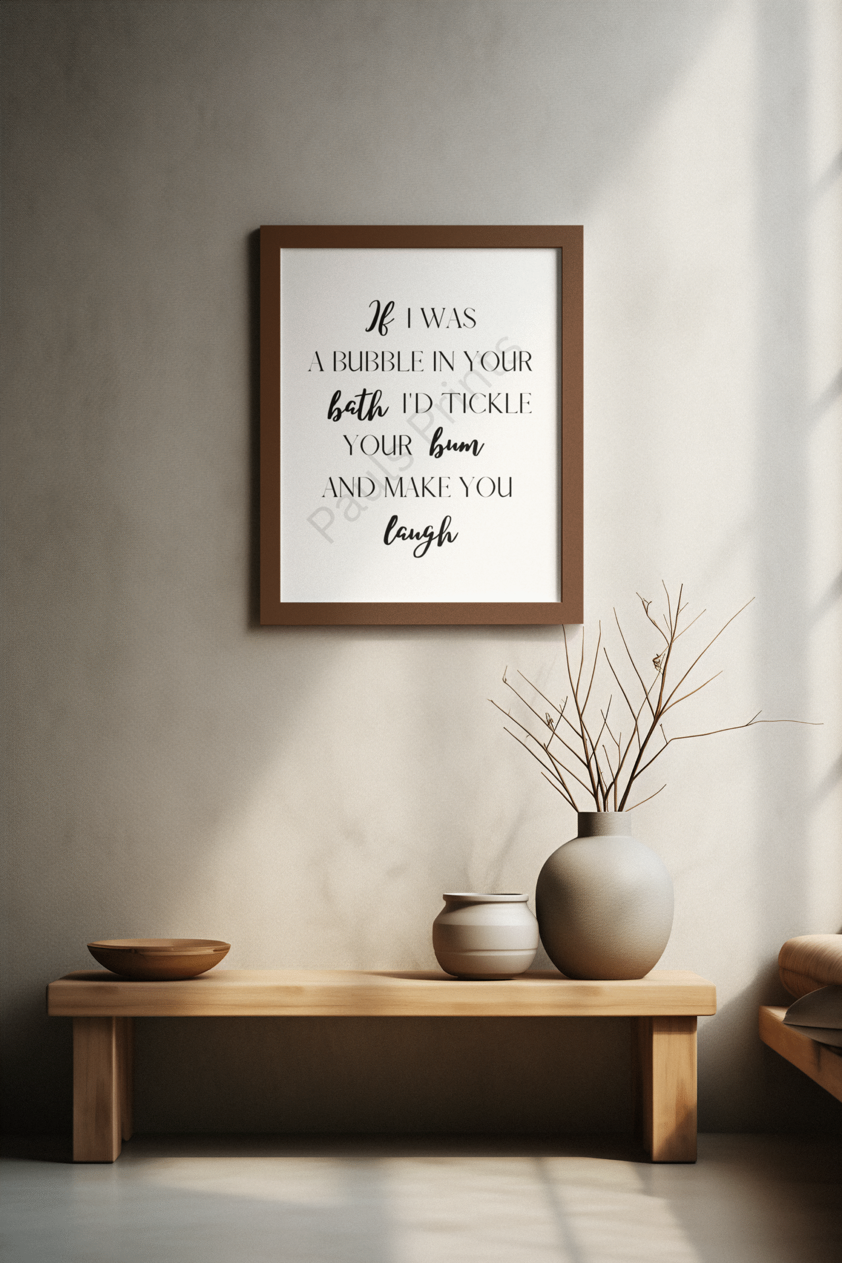 Brown-framed humorous bathroom print reading "If I was a bubble in your bath I'd tickle your bum and make you laugh," displayed above a wooden bench with decorative vases.