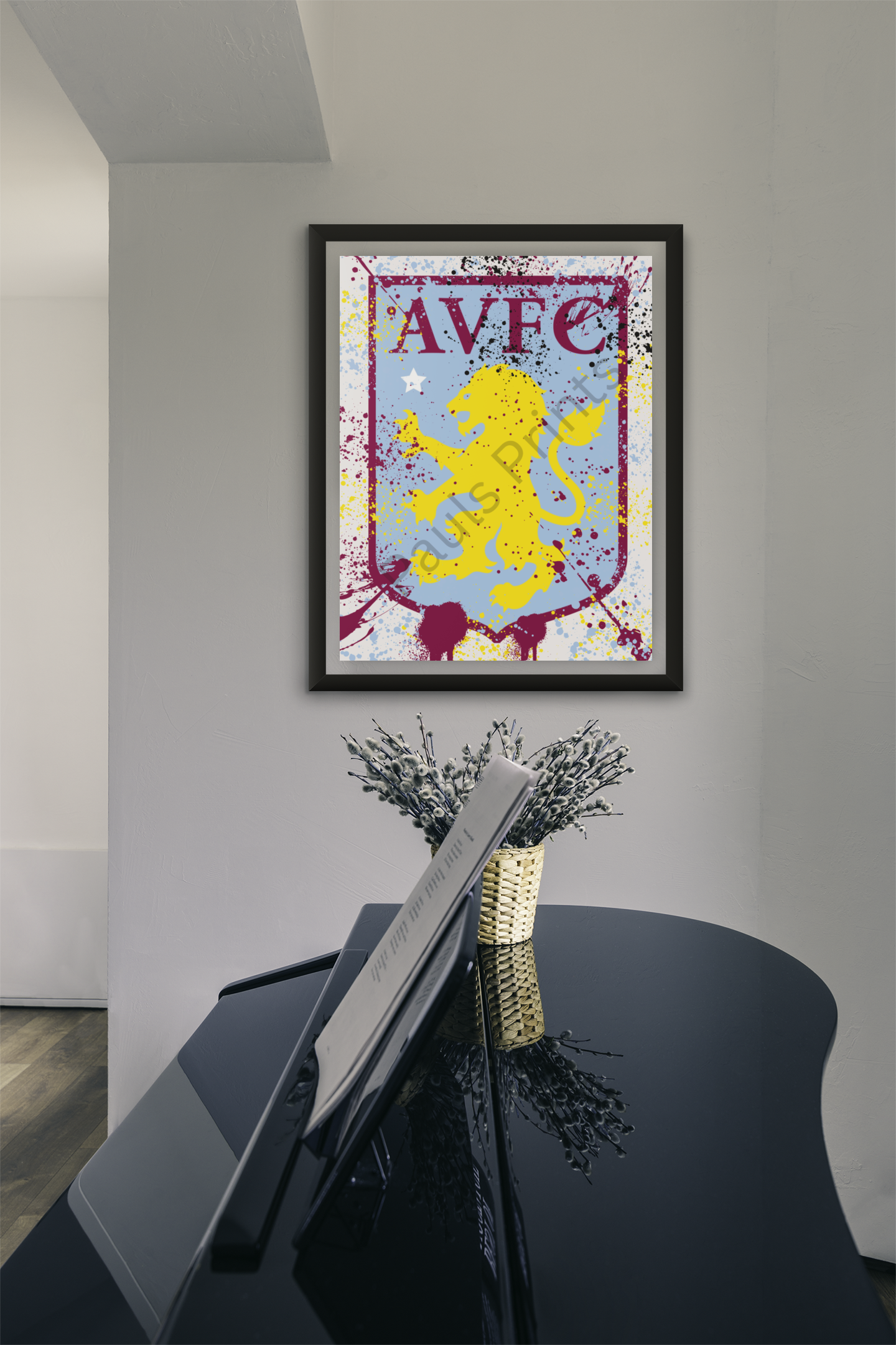 Aston Villa FC crest wall art in splatter paint design with black frame, hanging above a black piano in a stylish hallway.