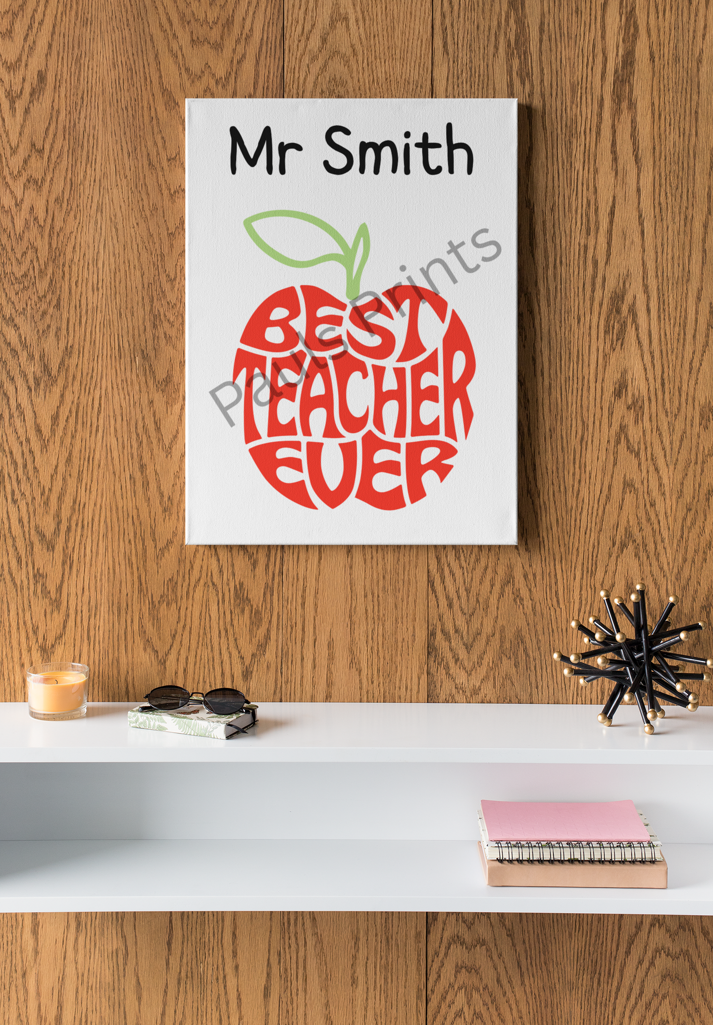 Personalised Best Teacher Ever canvas print with apple design, hanging on wooden wall above contemporary shelf decor.
