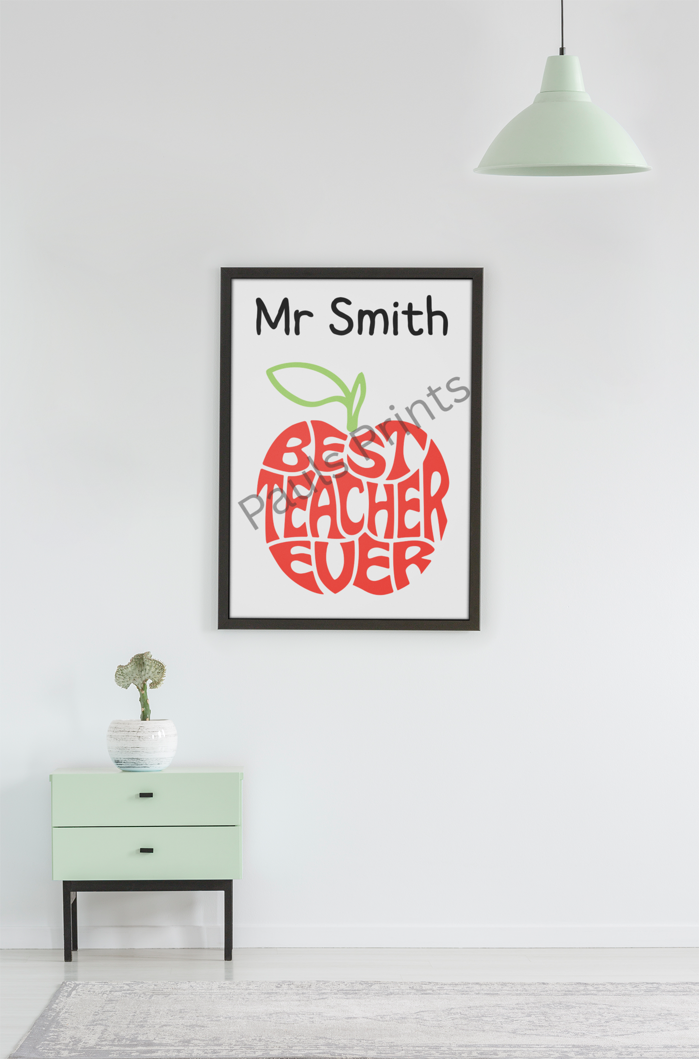 Large framed Best Teacher Ever apple print with name, hung above mint green cabinet in modern minimalist room.