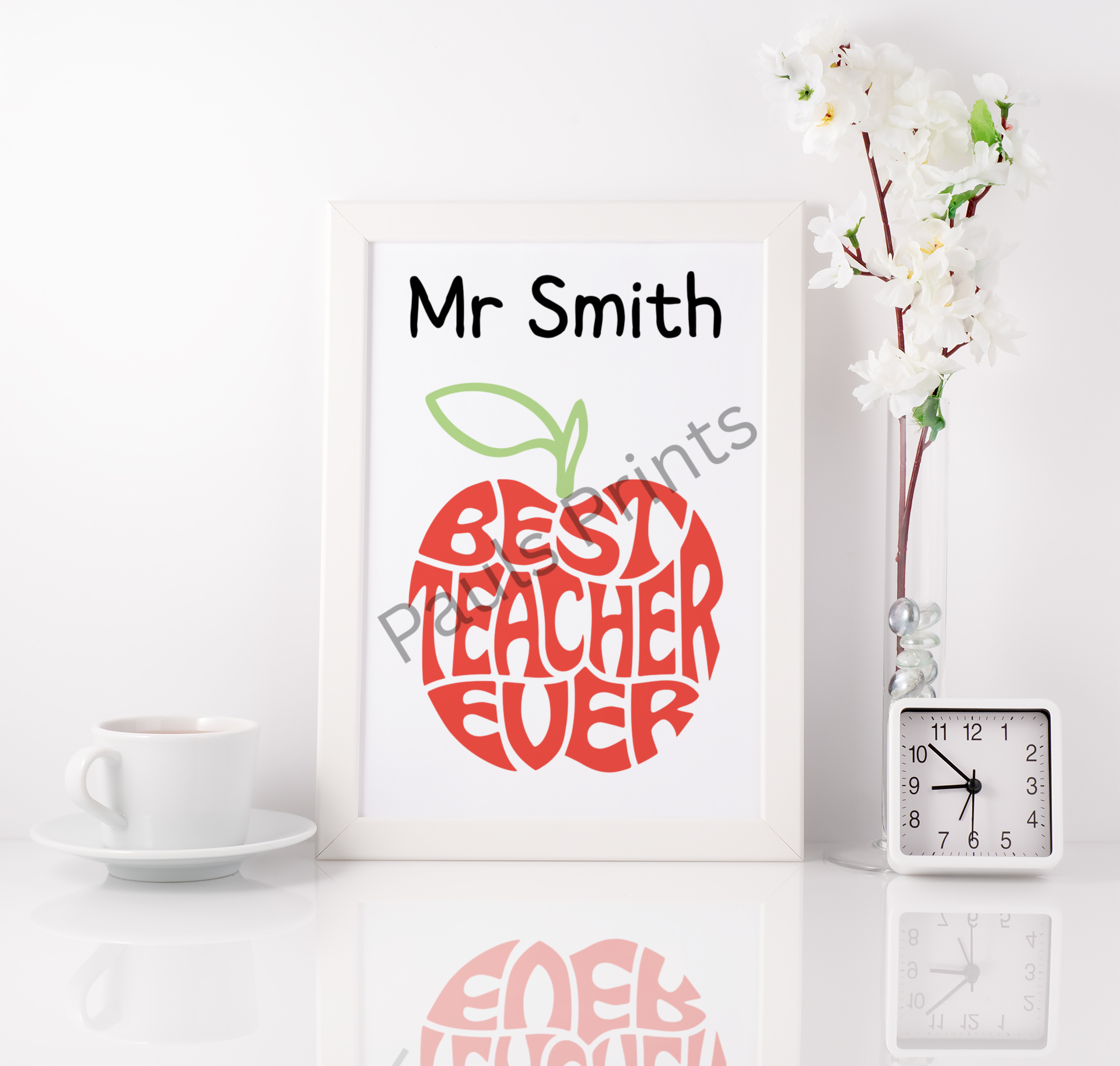Framed Best Teacher Ever print with personalised name, styled on a clean white desk with cup, flowers, and clock.
