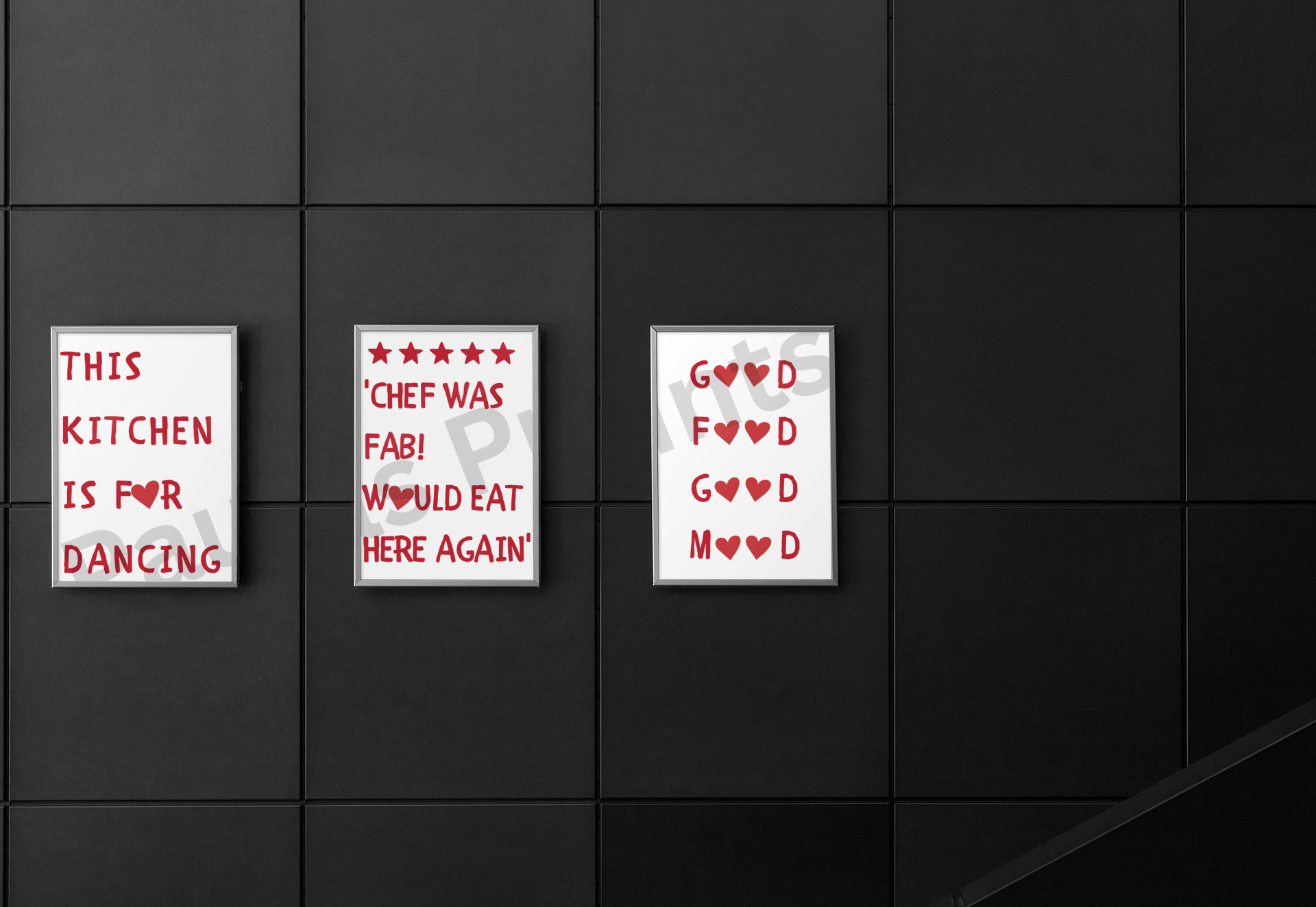 Trio of framed kitchen-themed prints with bold red typography and heart accents, displayed on a modern black tiled wall.