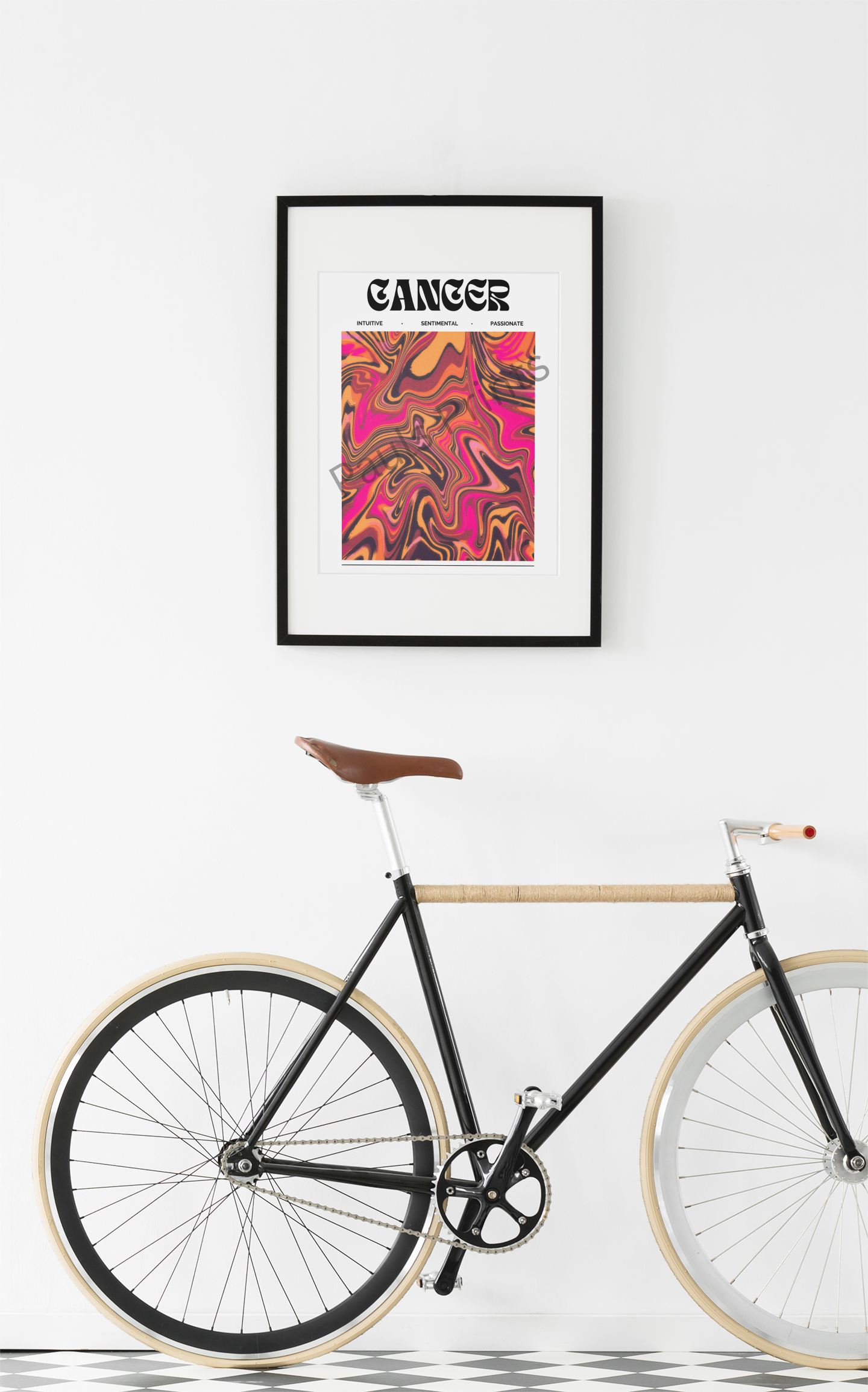 Framed Cancer zodiac print with swirling pink, orange, and black tones, hanging on a white wall above a stylish black bicycle with a leather seat.