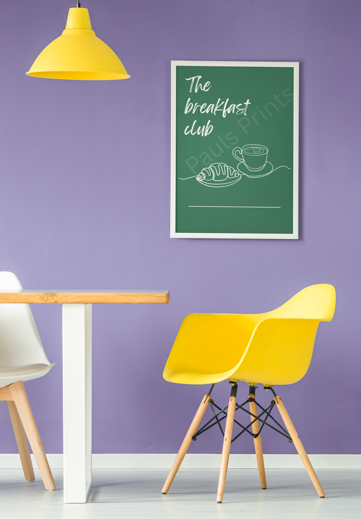 Breakfast Club poster with coffee and croissant line art, hanging on a purple wall above yellow and white dining chairs and a modern wood dining table.