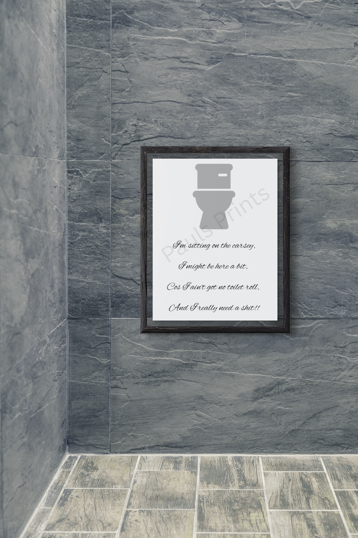 Framed humorous bathroom print with toilet graphic and playful rhyme, hung on a grey tiled bathroom wall.