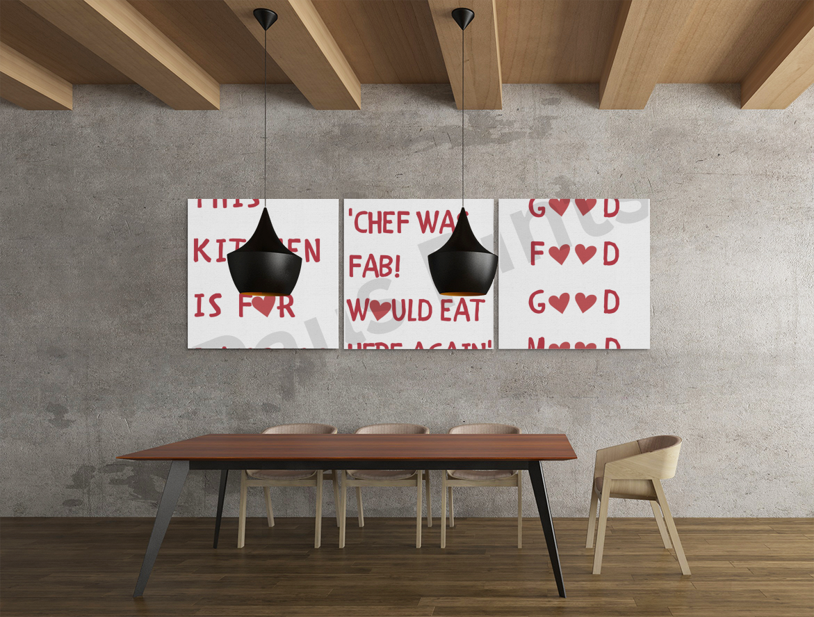 Three-panel humorous kitchen wall art in red text with heart icons, hanging above a modern dining table in an industrial-style room.