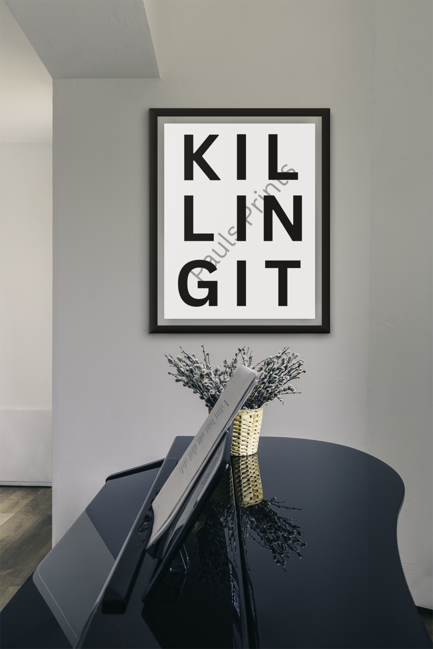 Framed “Killing It” minimalist print above a glossy black grand piano and a vase of branches, set in a modern music room.