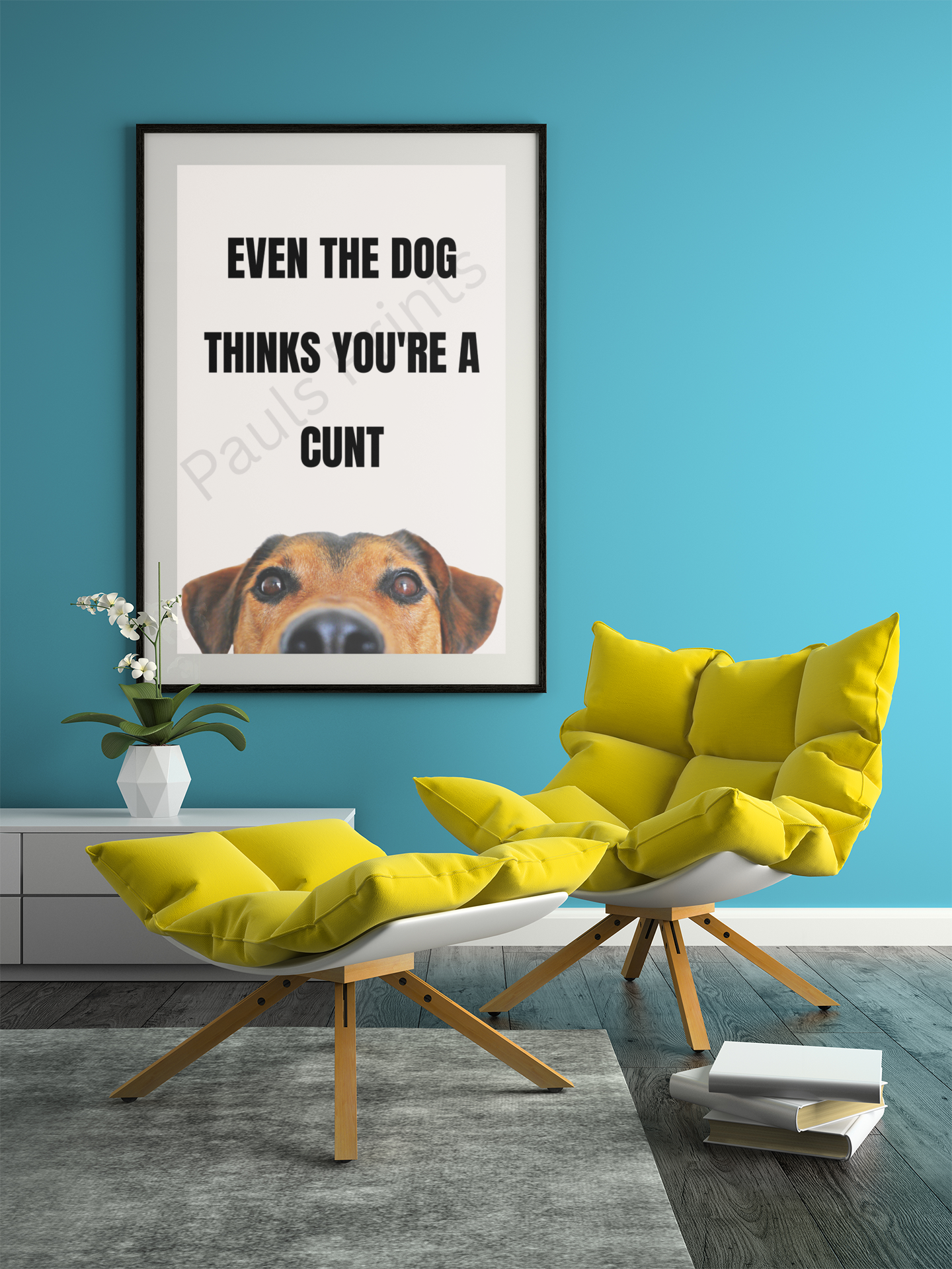 Oversized humorous dog quote print in black text with a dog’s head illustration, framed in black and hung on a blue wall above modern yellow lounge chairs.