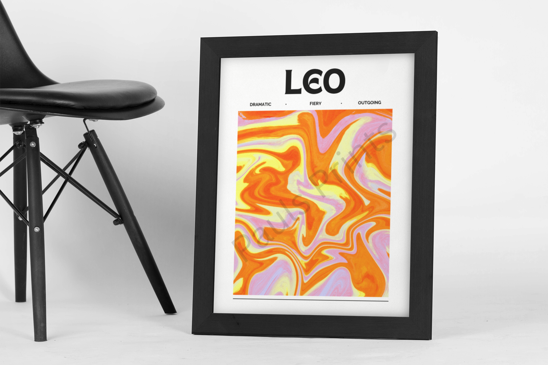Fiery Leo-themed wall print featuring bold orange and yellow abstract swirls, set in a sleek black frame beside a minimalist black chair.