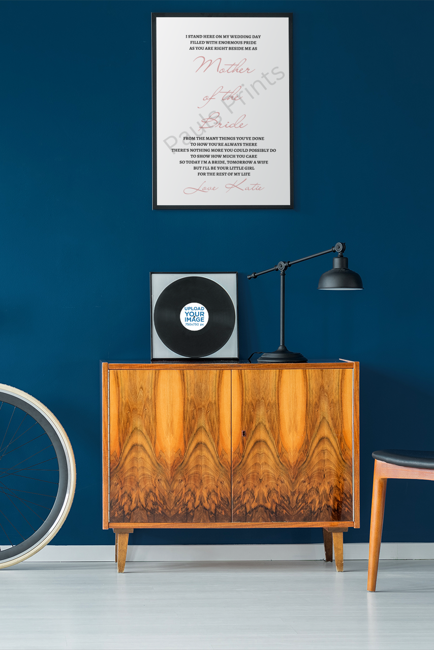 Wedding poem print in a sleek black frame hanging above a retro cabinet and record player against a navy blue wall.