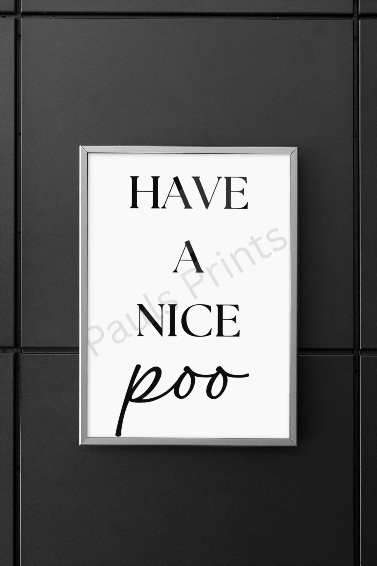 Stylish silver framed bathroom wall art with the playful text “Have a Nice Poo,” mounted on a modern dark grey paneled wall.