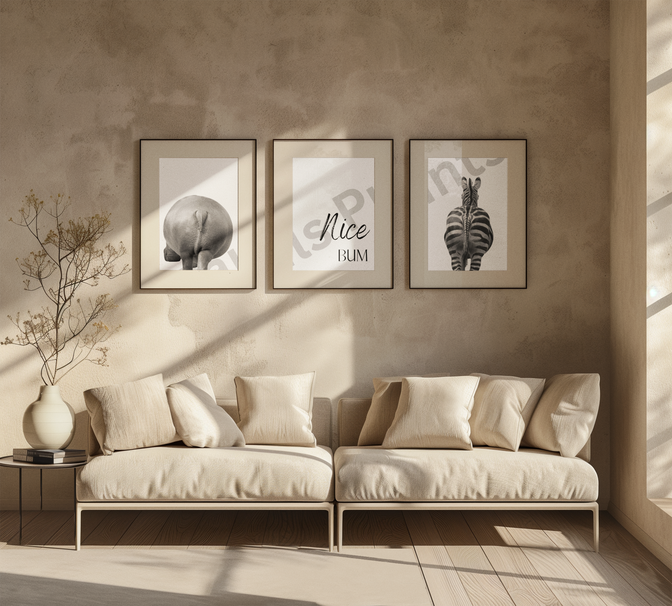 Earthy-toned, minimalist lounge with cream sofas and a triptych wall art featuring a hippo, “Nice Bum” text, and zebra in neutral frames.