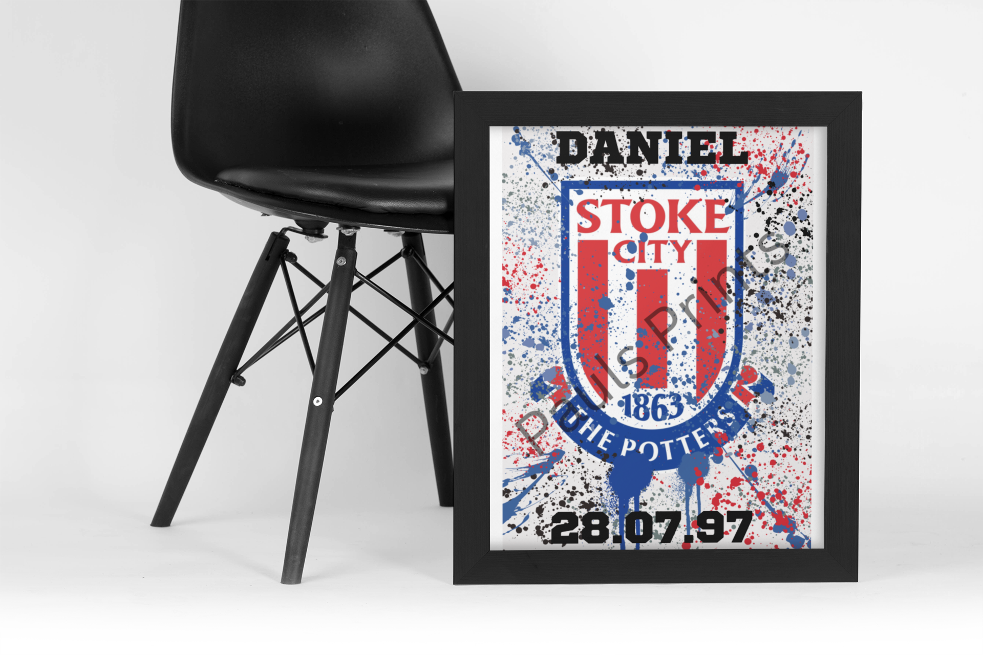 Customised Stoke City FC print featuring red splatter design, shown leaning on black chair against a white backdrop.
