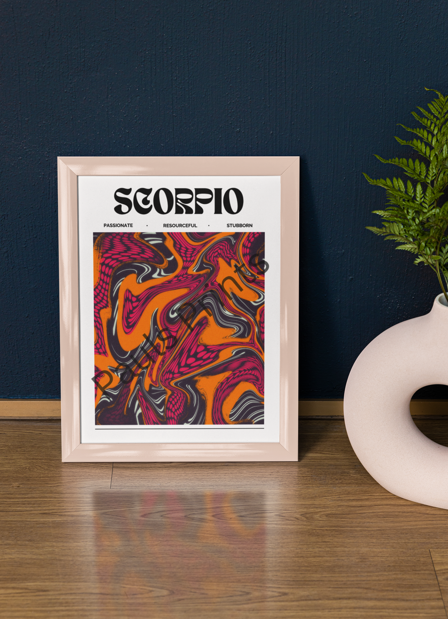 Scorpio zodiac artwork in a shiny peach frame, leaning against a deep blue wall next to a round sculptural white vase with green fern.