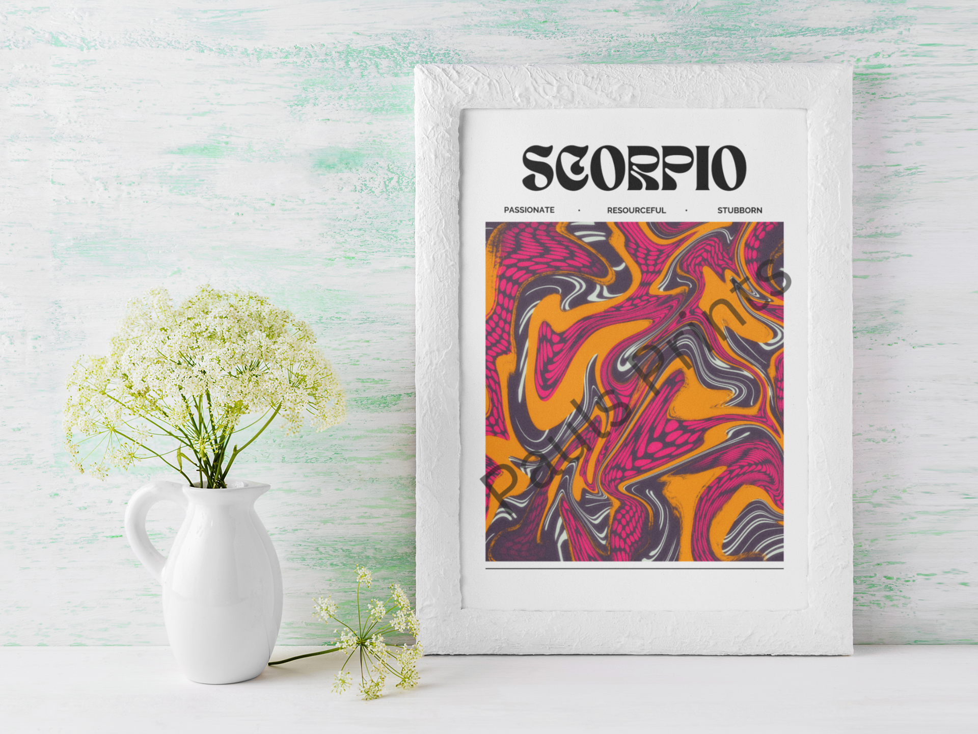 Scorpio star sign print in vivid orange and fuchsia tones, set in a textured white frame beside a white jug of delicate wildflowers.