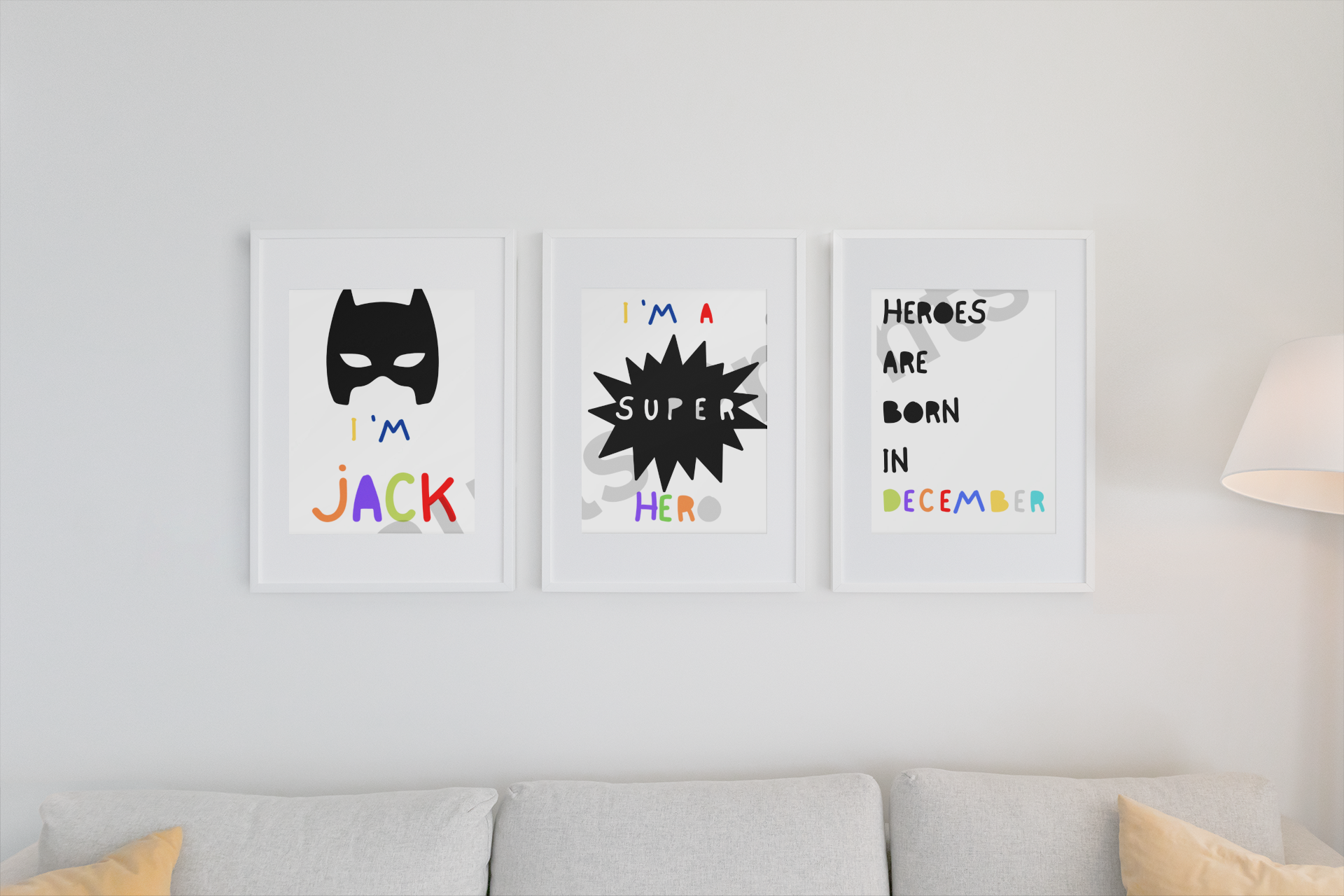 A neat, clean sofa setup is accented with a trio of framed superhero prints featuring a mask graphic, comic-style typography, and December-themed message.
