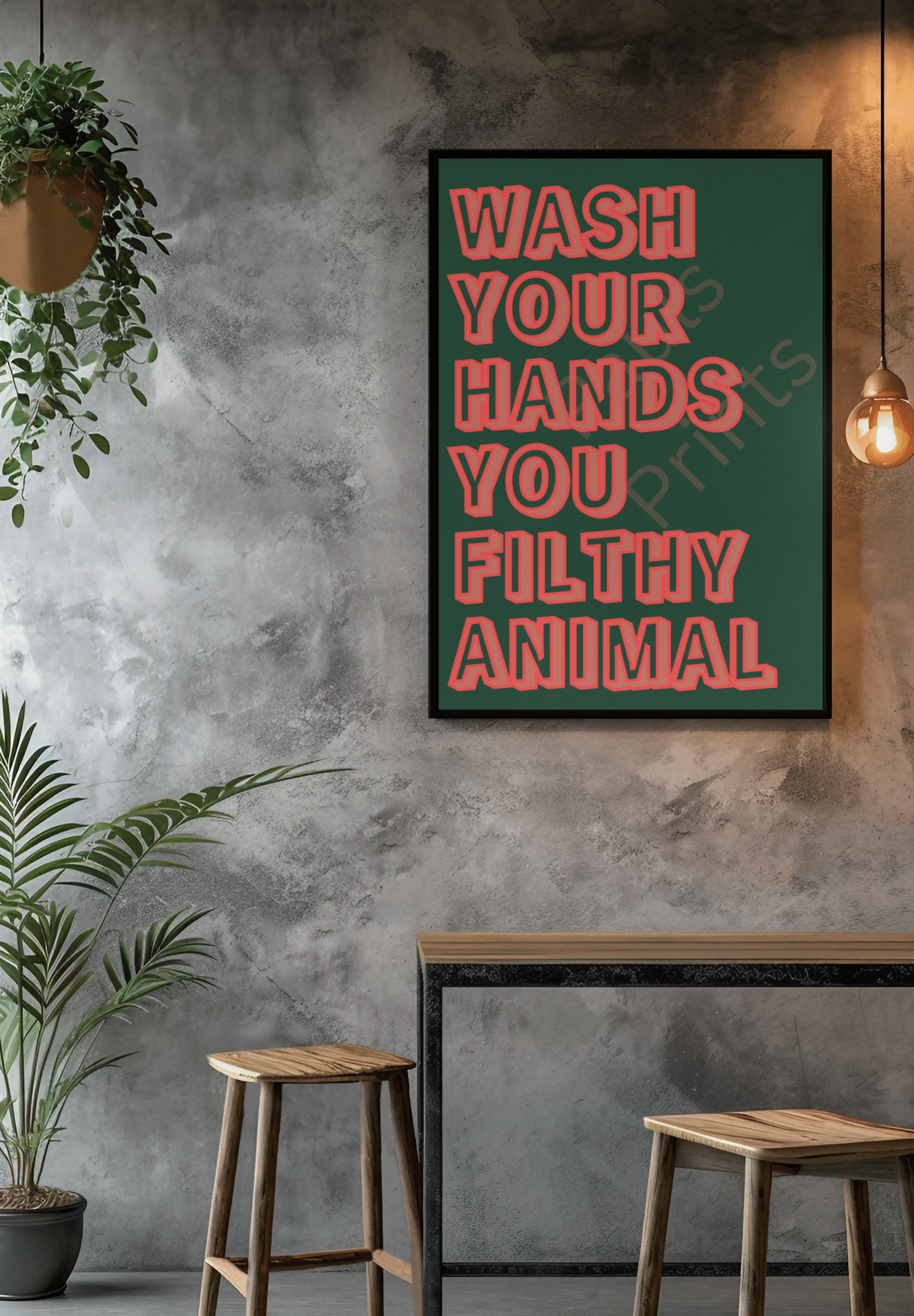 Bold humorous wall art with red outlined letters on a dark green background reading “Wash Your Hands You Filthy Animal,” framed in black and hung on a grey wall above decorative vases and plants.
